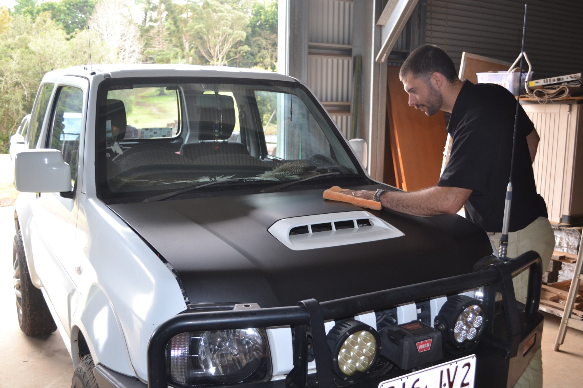 Antoine working on the bonnet of a Suzuki Jimny